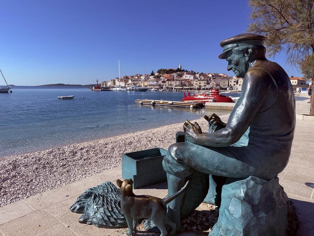 Escultura del pescador con Primošten al fondo