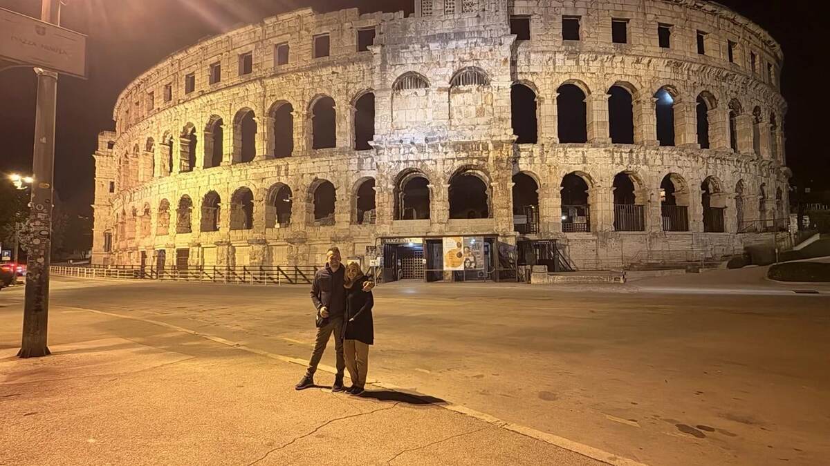 Txema y Alaitz frente a la Arena de Pula iluminada de noche