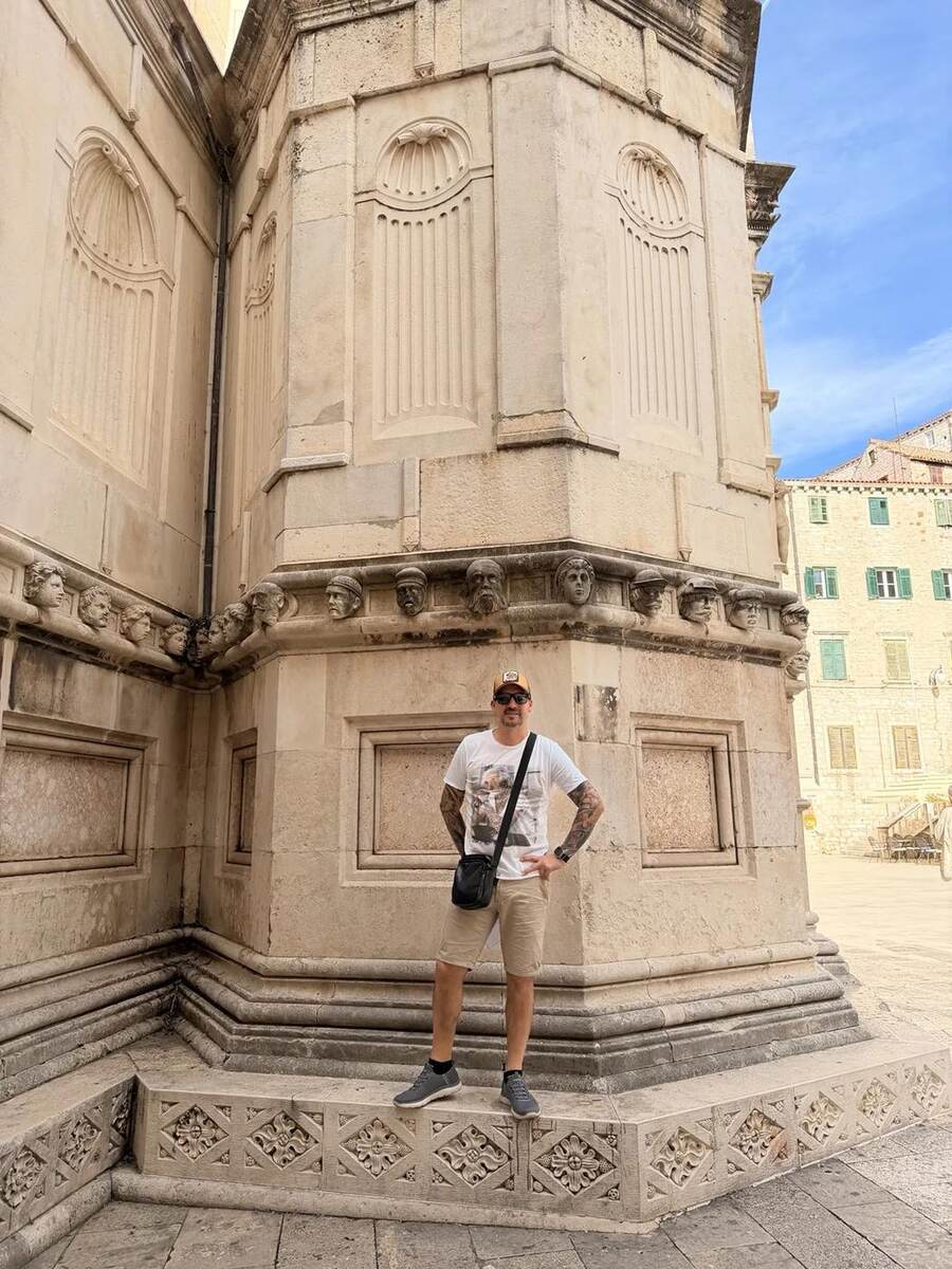 Txema junto al friso de cabezas de la catedral