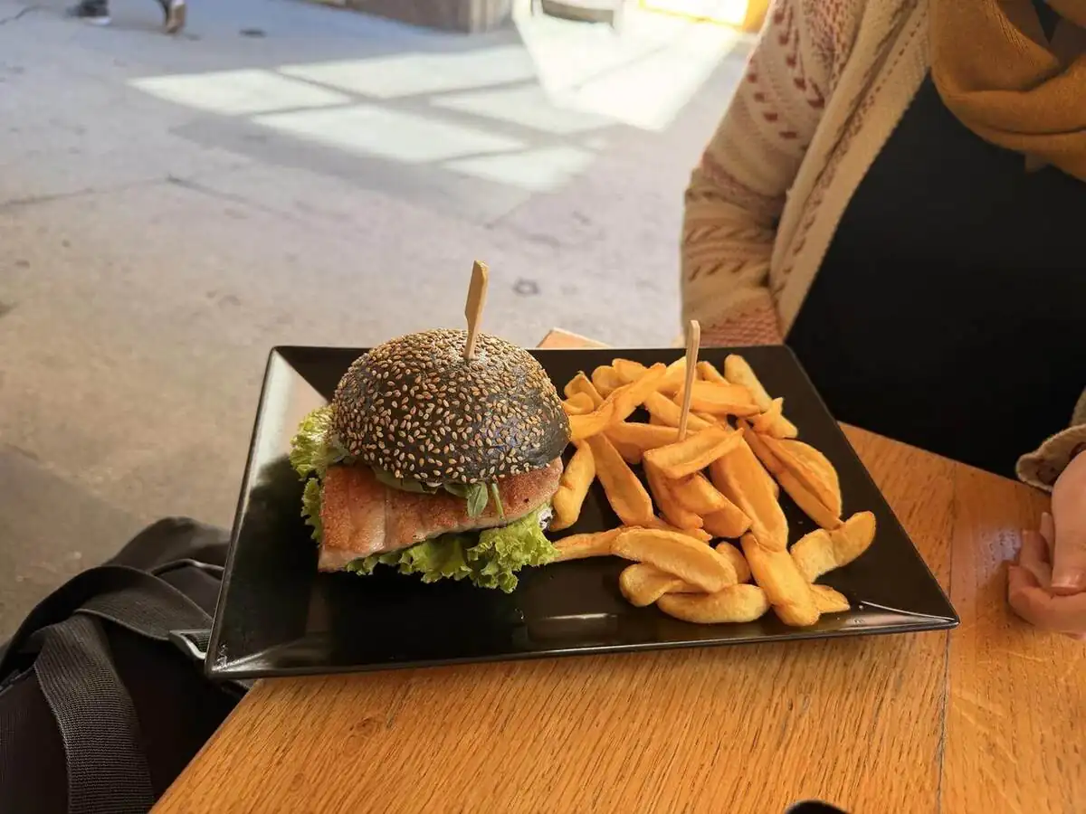 Hamburguesa con pan negro servida en 69 Food de Pula