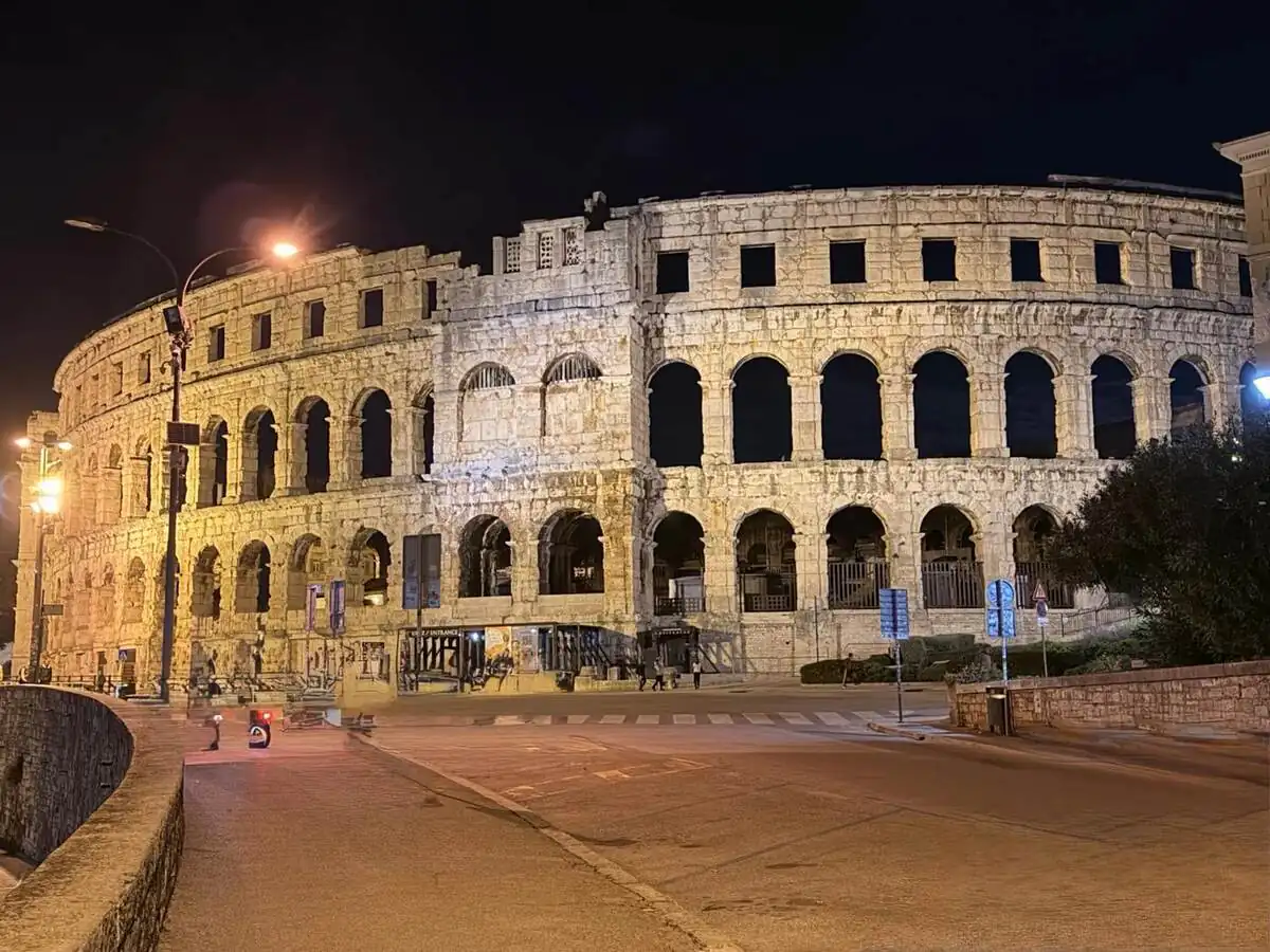 Exterior de la Arena de Pula iluminado durante la noche