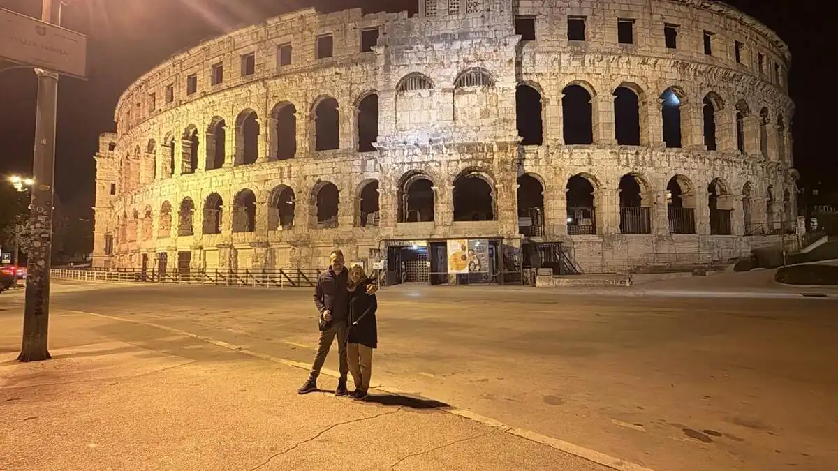 Txema y Alaitz frente a la Arena de Pula iluminada de noche