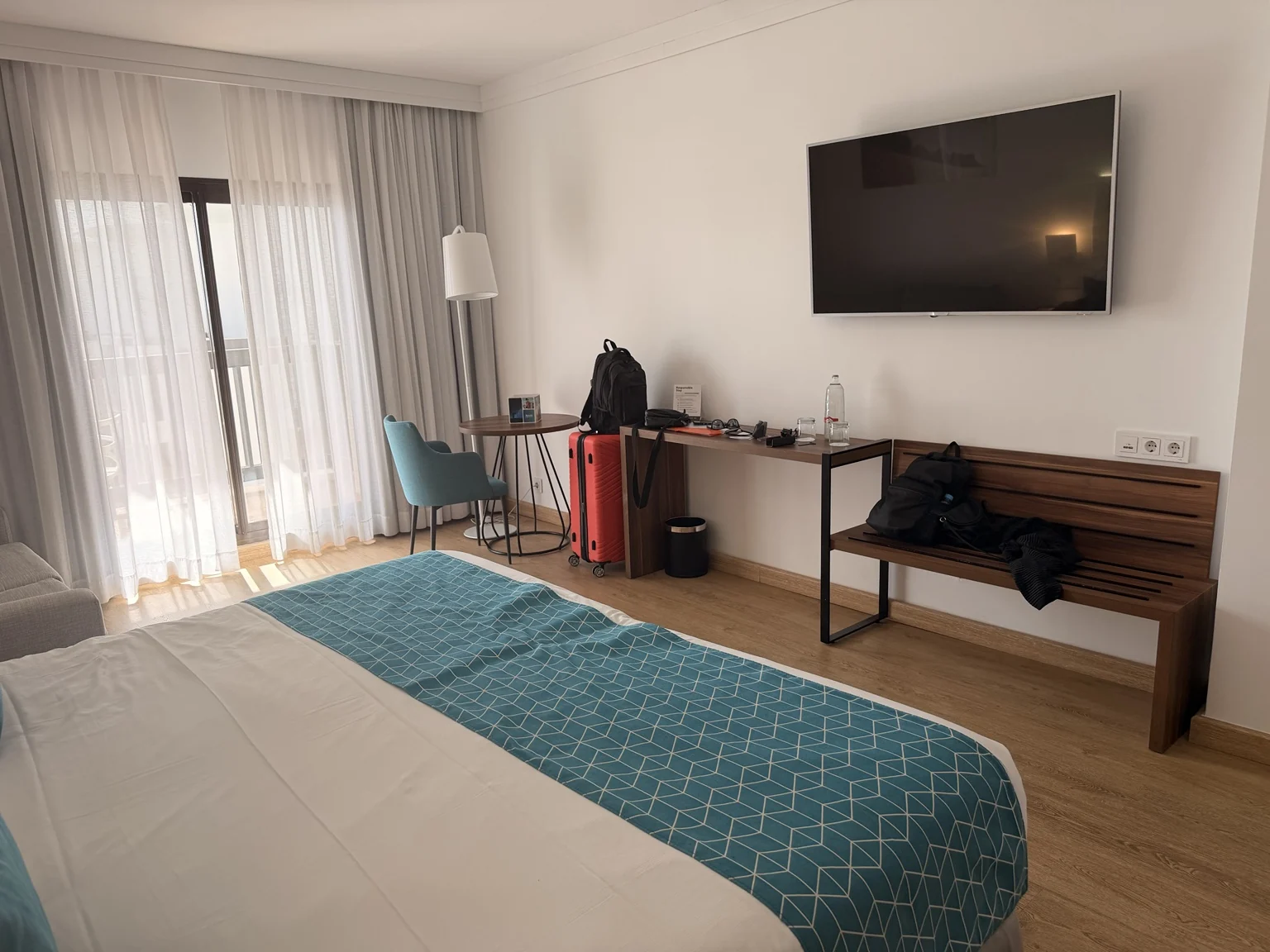 Vista de la habitación con televisión, escritorio y zona de equipaje