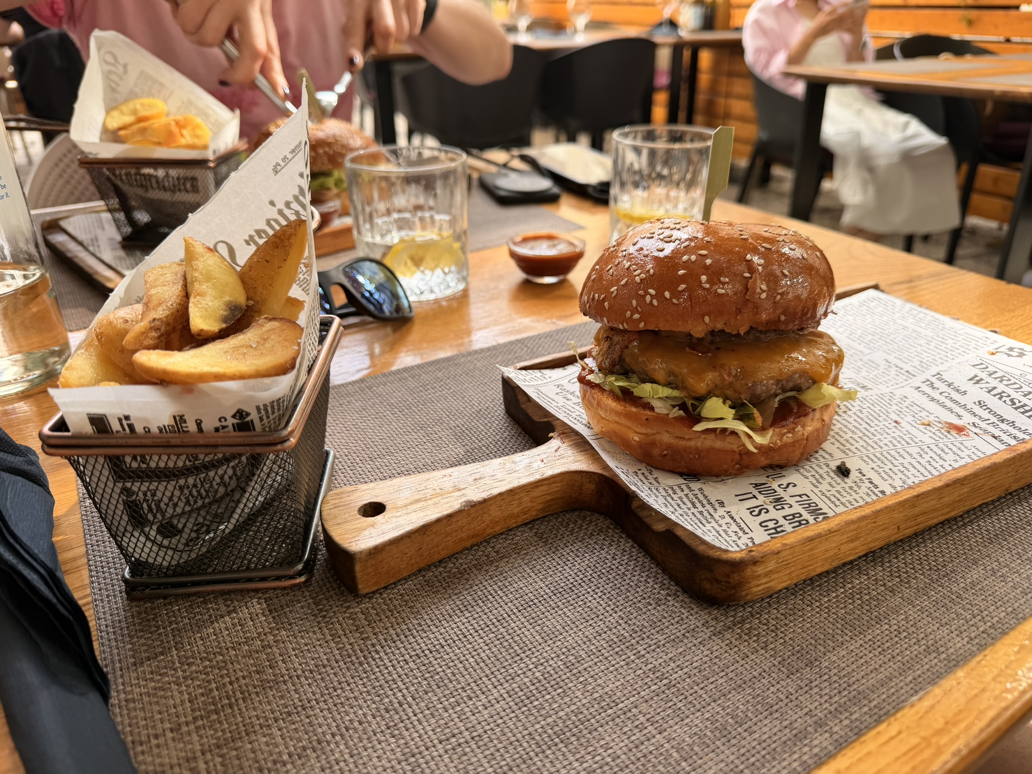 Varias hamburguesas con patatas, salsas y bebidas en Bistro Bava