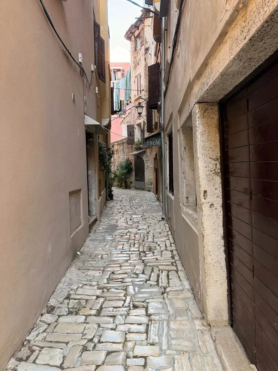 Calle estrecha de piedra durante la subida por el casco antiguo de Rovinj