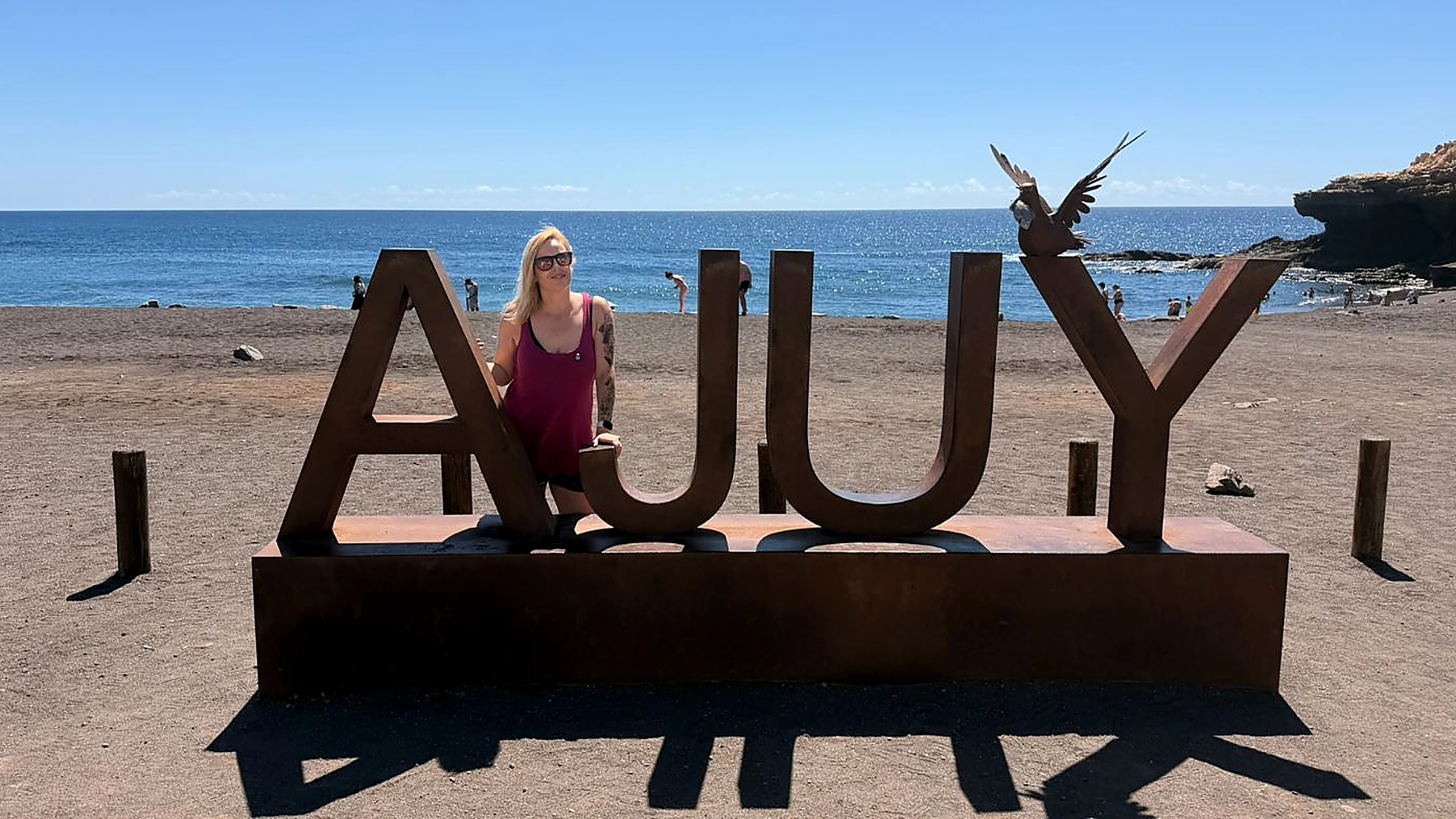 Alaitz junto al gran cartel de Ajuy frente a la playa de arena negra