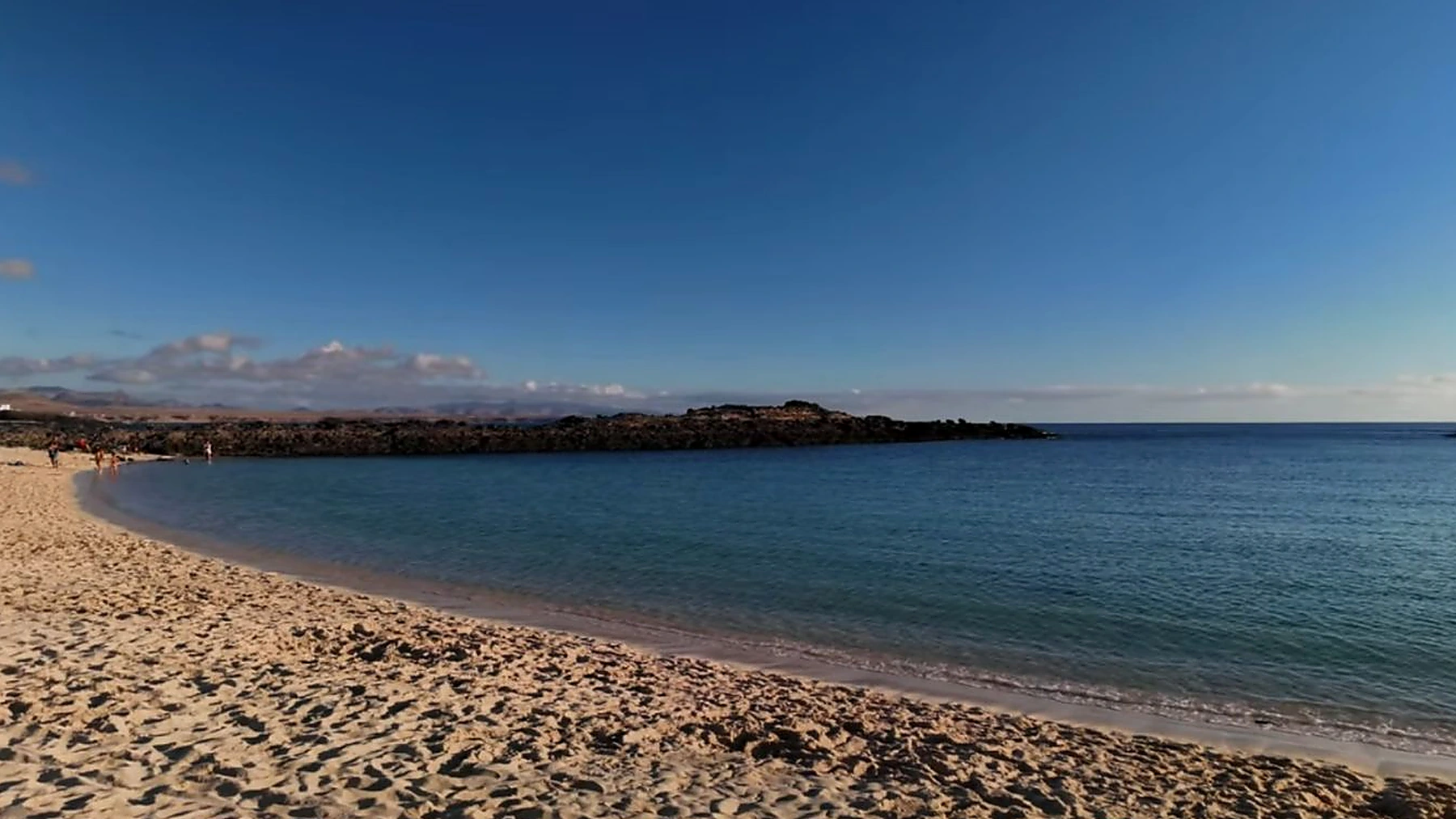 Arena clara y agua en calma en Playa de La Concha de El Cotillo