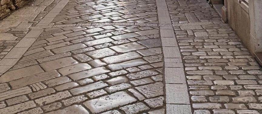 Detalle del empedrado y las losas pulidas de la calle Decumanus