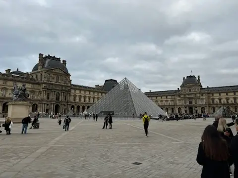 Pirámide del Louvre bajo un cielo nublado