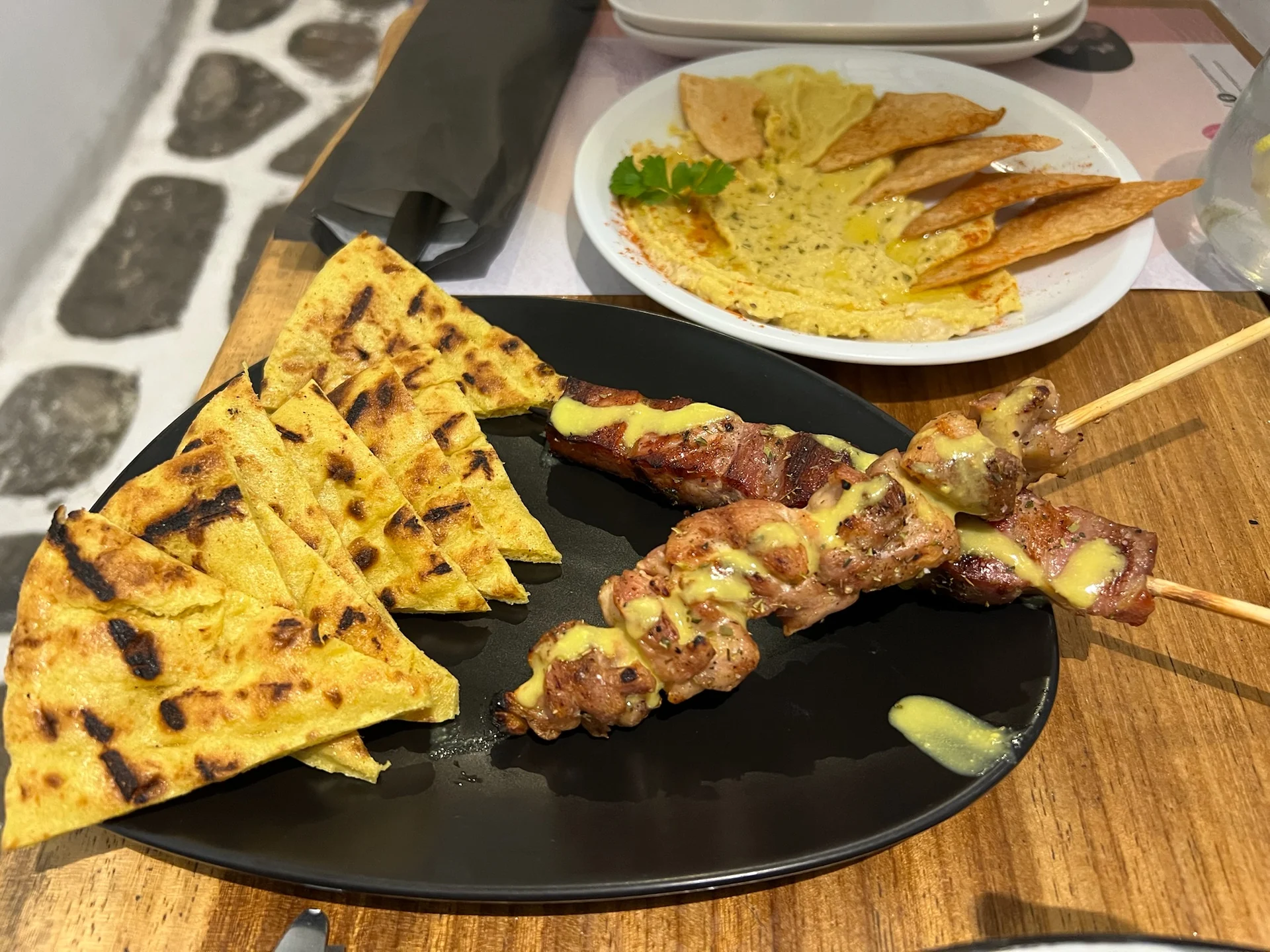 Souvlaki con pan de pita servido en Pepper Mykonos