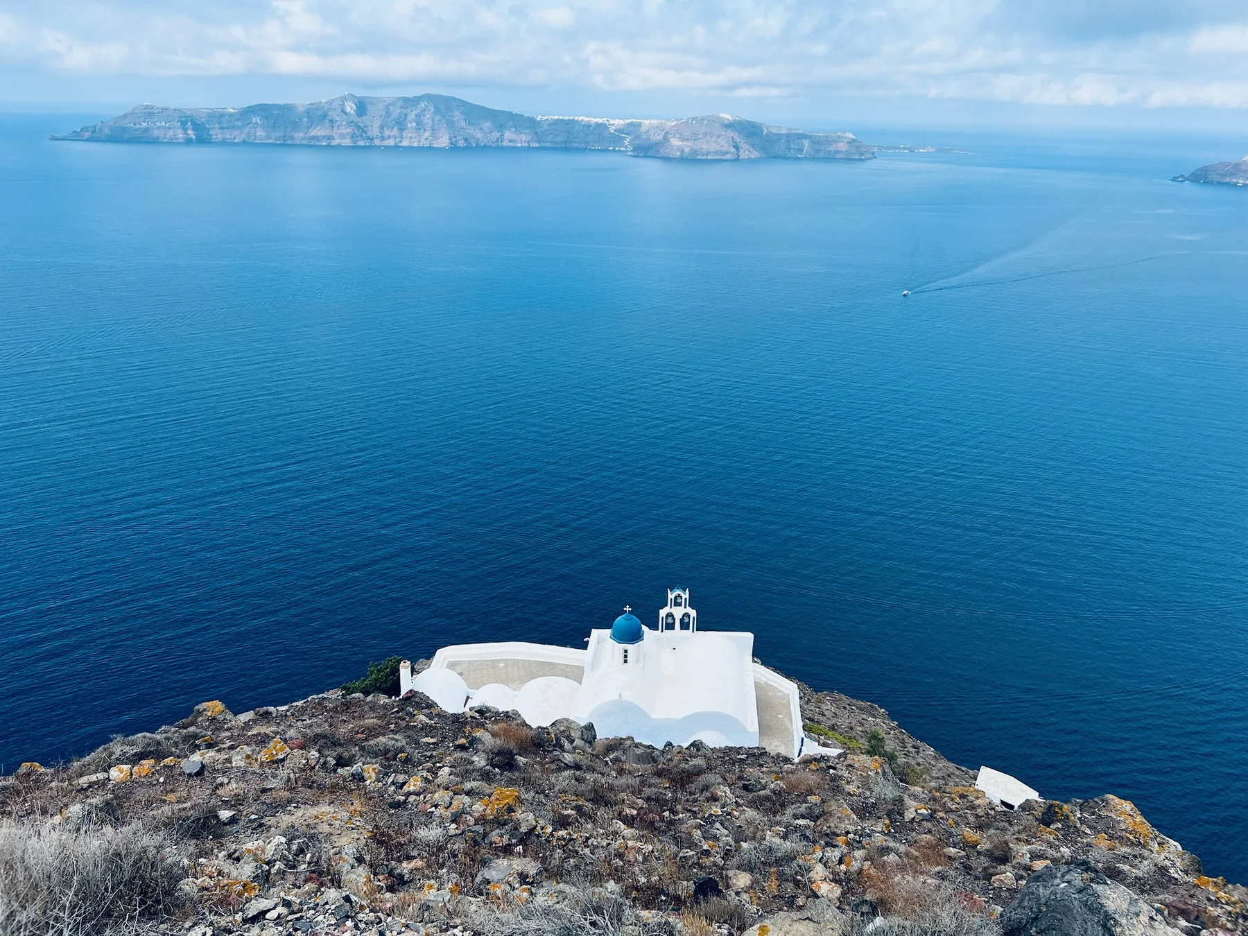 Vista nítida de la caldera de Santorini y una capilla blanca desde la zona de Skaros