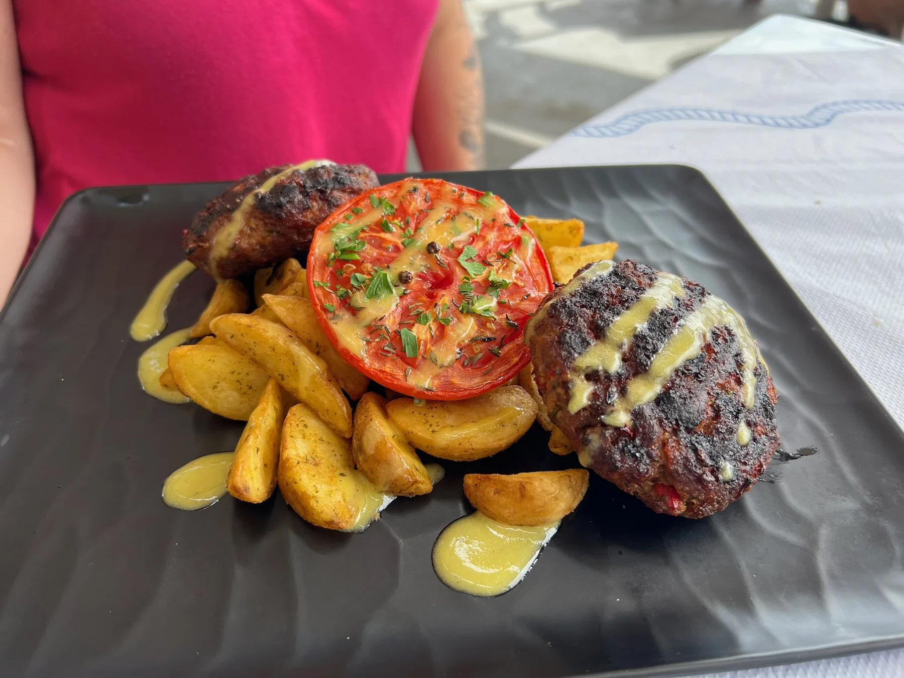Plato de carne con patatas durante la comida en Thirasia