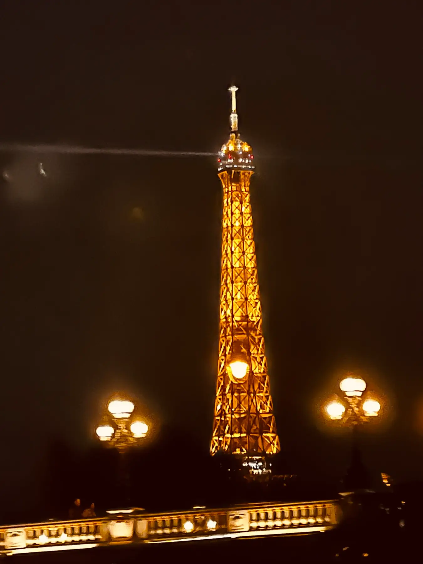 Detalle nocturno de la Torre Eiffel iluminada