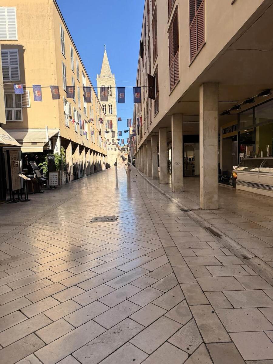 Calle peatonal del casco histórico de Zadar con el campanario al fondo