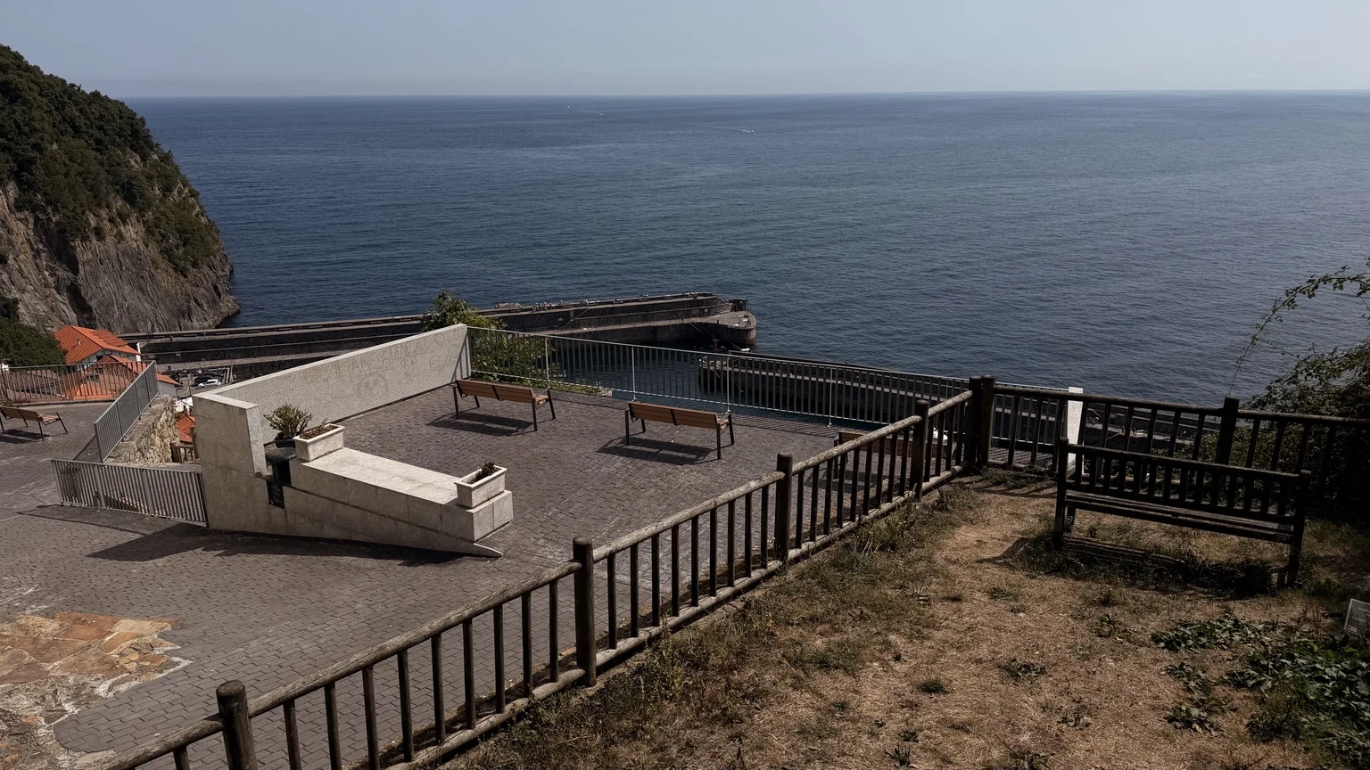 Mirador con bancos sobre el puerto y el mar en Elantxobe