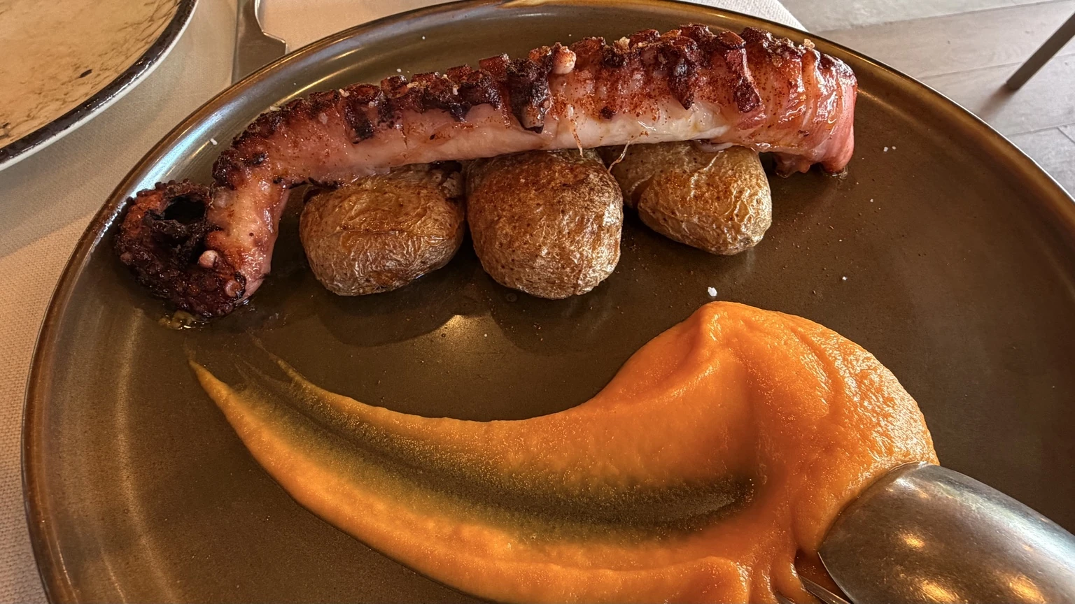 Pulpo a la brasa con patatas y crema servido en Kanala Beach