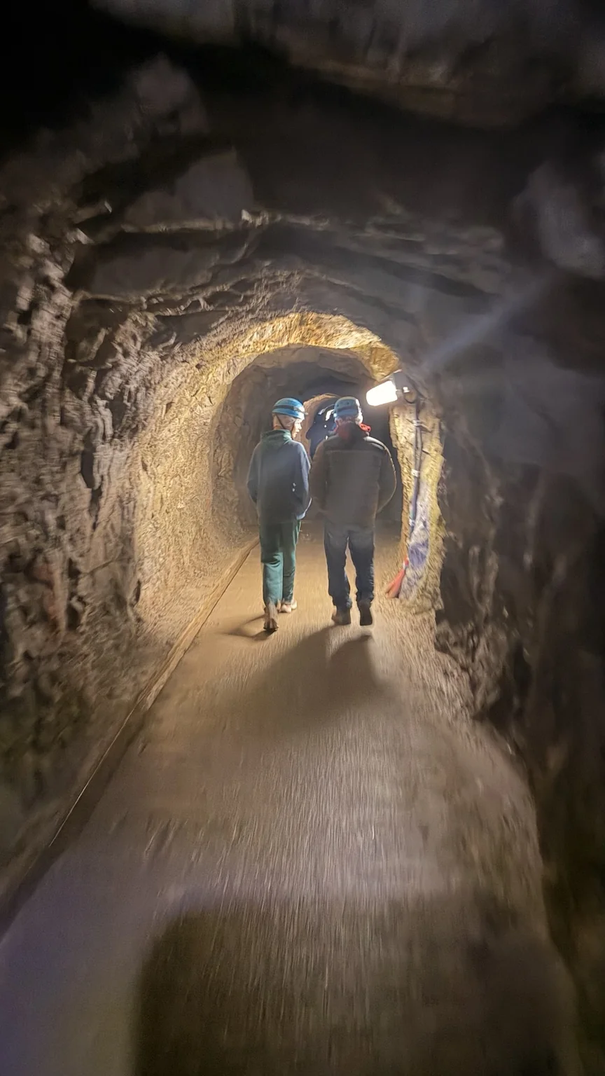 Túnel de acceso a La Verna con visitantes equipados con casco