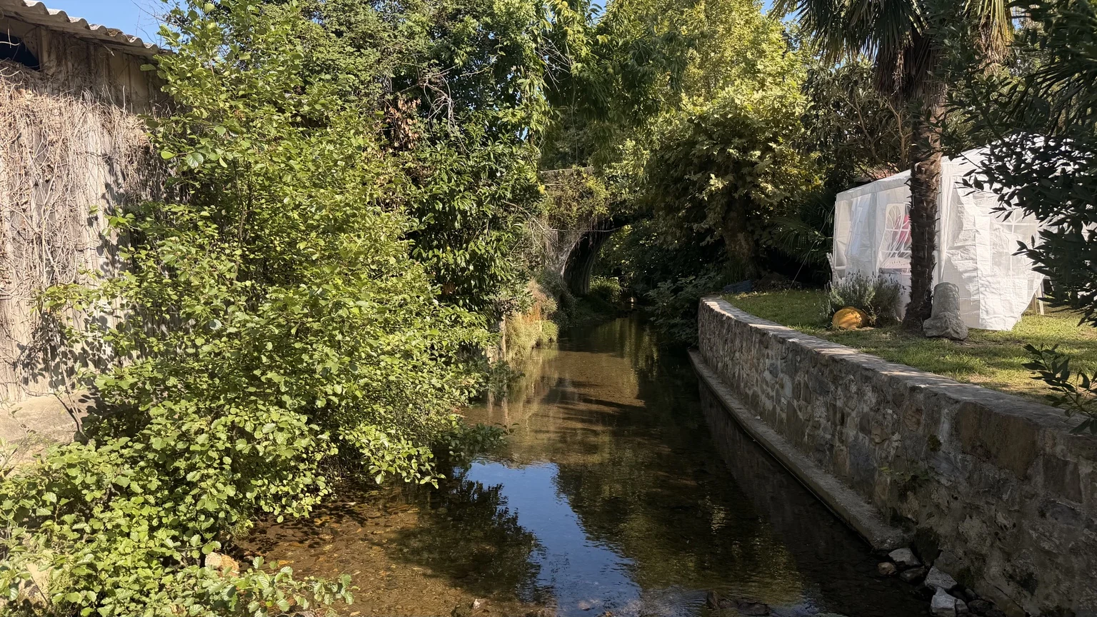 Arroyo de Espelette entre vegetación y muros de piedra
