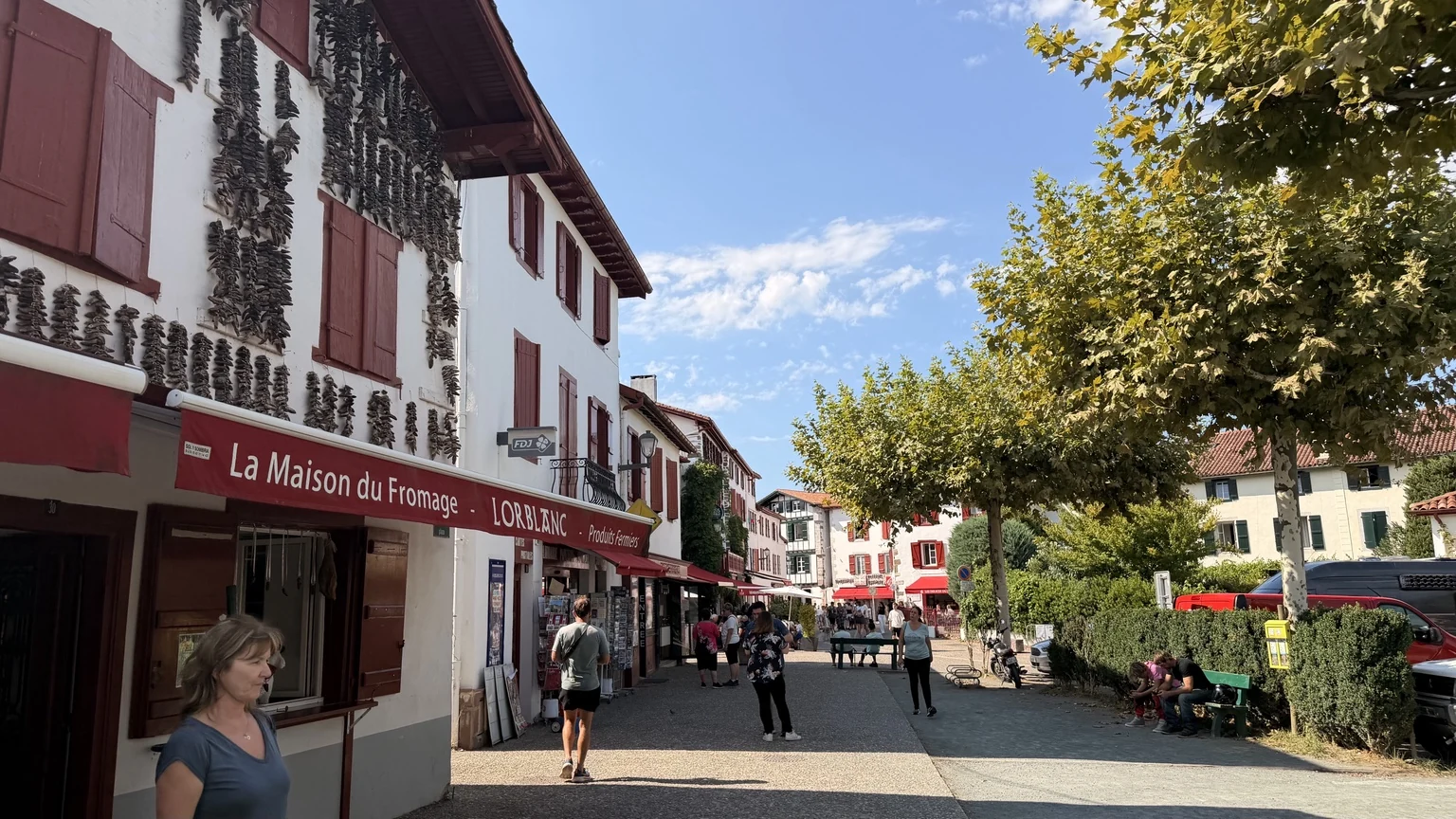 Calle de Espelette con fachadas blancas y rojas, tiendas y ambiente
