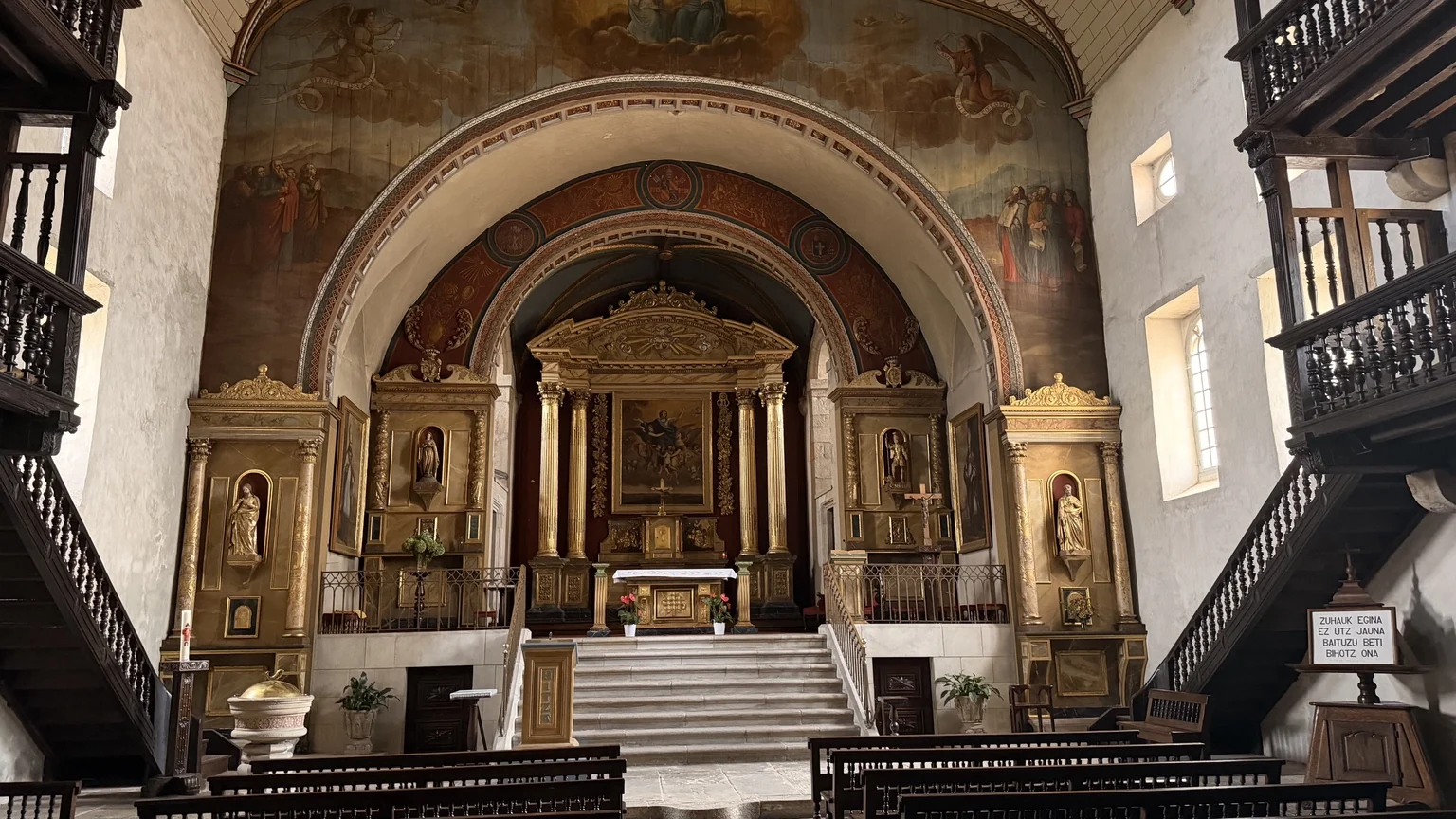 Interior de la iglesia de Saint-Martin de Sare con altar y galerías laterales de madera